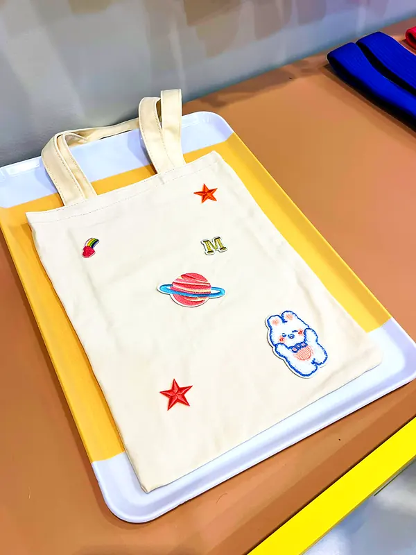 Tote bag écru décoré de planètes, étoiles et lettre brodée